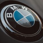 Close-up of a shiny BMW logo on a luxury car, emphasizing modern design.